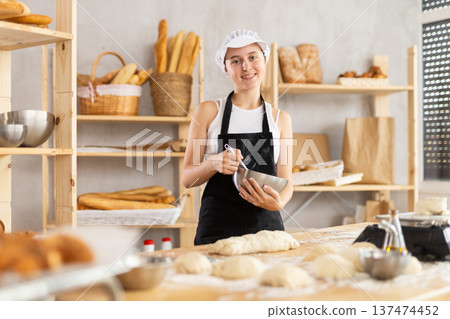 Teenage girl baker whipping dough in bowl 137474452