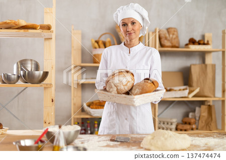 Adult woman with homemade bread in bakery Adult woman with homemade bread in bakery 137474474
