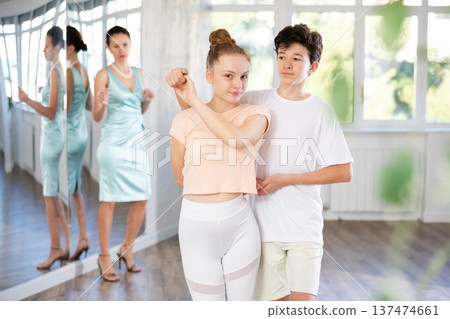 Teenage girl and boy practicing waltz in dance hall with female mentor Teenage girl and boy practicing waltz in dance hall with female mentor 137474661