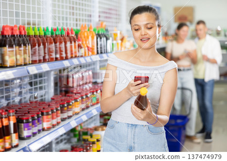 Woman looking for chili sauce using code on internet 137474979