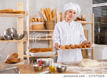 Adult woman with fresh croissants in bakery Adult woman with fresh croissants in bakery 137475009