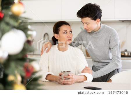 Domestic quarrel during christmas - teenage son trying to apologize to mother after domestic disagreement on christmas day Domestic quarrel during christmas - teenage son trying to apologize to mother after domestic disagreement on christmas day 137475046