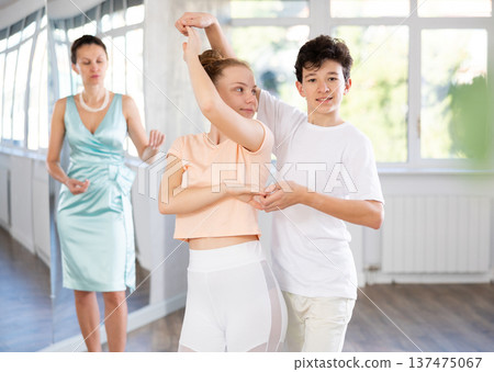 Motivated adolescent ballroom dancers practicing dance moves in studio 137475067