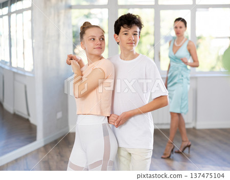 Girl and a boy are having fun learning to dance tango at choreographic school 137475104