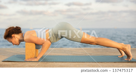Female yoga instructor performing various asana poses using rectangular blocks Female yoga instructor performing various asana poses using rectangular blocks 137475317