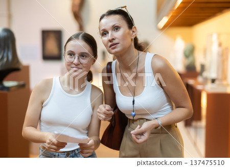 Young woman with teen daughter walk around museum, view sculpture in museum hall Young woman with teen daughter walk around museum, view sculpture in museum hall 137475510