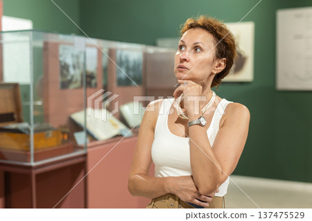 Middle-aged woman looking at exhibits in historical museum 137475529