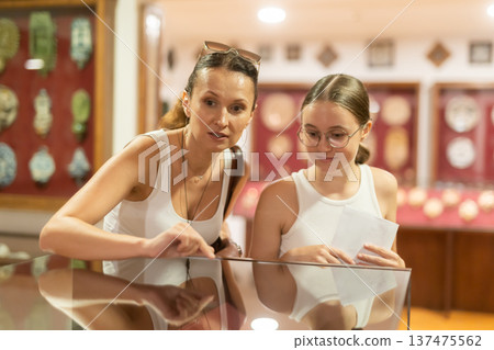 Woman and teenage girl looking at exhibit in museum display 137475562
