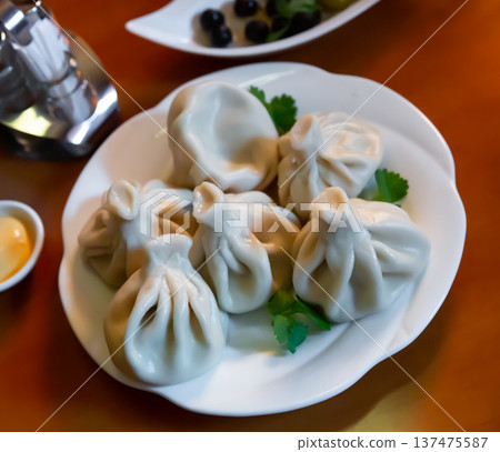 Khinkali, Georgian dumplings with sauce and parsley Khinkali, Georgian dumplings with sauce and parsley 137475587