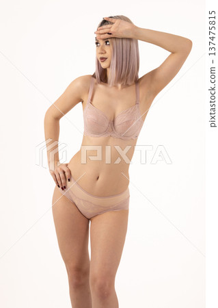 Beautiful woman posing in beige set against white background Beautiful woman posing in beige set against white background 137475815