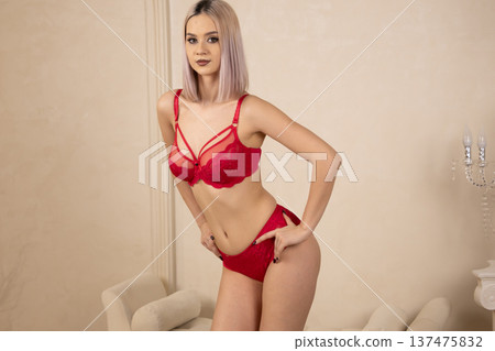 Beautiful woman posing in red set against neutral background 137475832