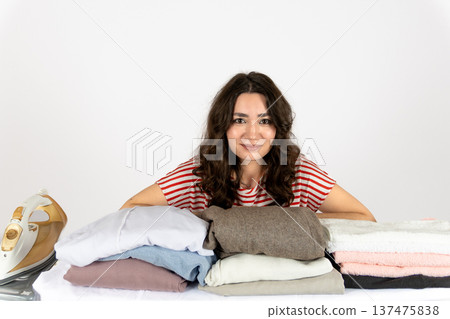 Woman with messy laundry pile looking at camera 137475838