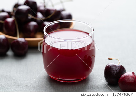 Glass of cherry juice and fresh cherries on a cotton fabric background, Healthy drink Glass of cherry juice and fresh cherries on a cotton fabric background, Healthy drink 137476367