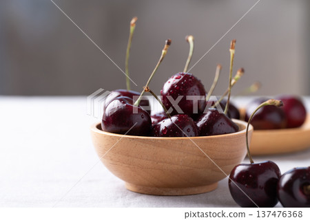 Fresh red cherries with water droplets in a wooden bowl Fresh red cherries with water droplets in a wooden bowl 137476368