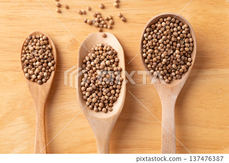 Coriander seeds in a wooden spoon on a wooden background, Top view of Thai food ingredients 137476387