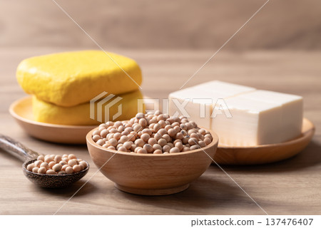 Assorted soy products: Raw soybeans, soft and firm tofu on wooden background Assorted soy products: Raw soybeans, soft and firm tofu on wooden background 137476407