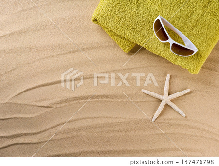 Beach towel and sunglasses on sandy beach, top view with space for text. 137476798