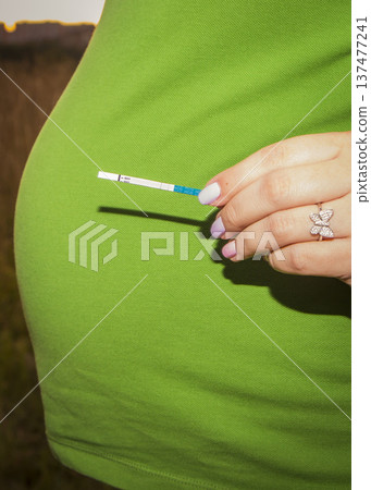 moscow, russia, 27.08.2015 A woman is holding a pregnancy test in her hand moscow, russia, 27.08.2015 A woman is holding a pregnancy test in her hand 137477241
