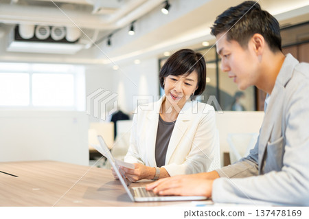 Men and women having a meeting in a coworking space Men and women having a meeting in a coworking space 137478169