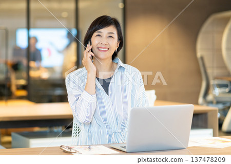 Middle-aged woman working in a coworking space 137478209