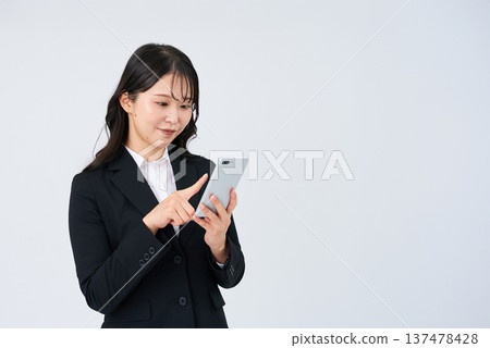 Business woman operating a smartphone Business woman operating a smartphone 137478428