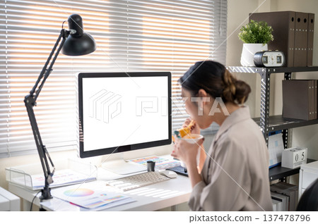 Asian businesswoman office worker eating instant noodle aside white screen mockup computer on table. Asian businesswoman office worker eating instant noodle aside white screen mockup computer on table. 137478796
