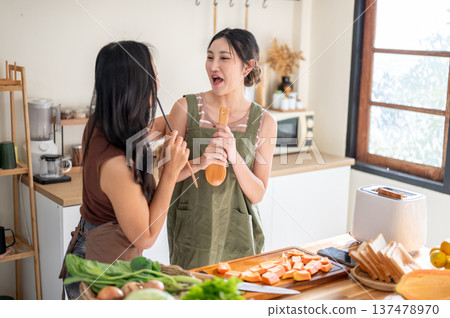 Asian woman girlfriend holding spatula funny singing at kitchen cooking counter with food ingredient 137478970