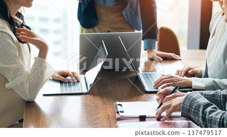 Group of casual business people meeting in an office Group of casual business people meeting in an office 137479517
