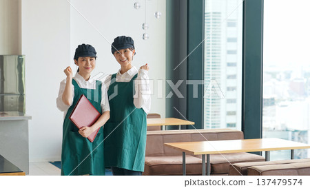 A restaurant employee pumping his fist in the store 137479574