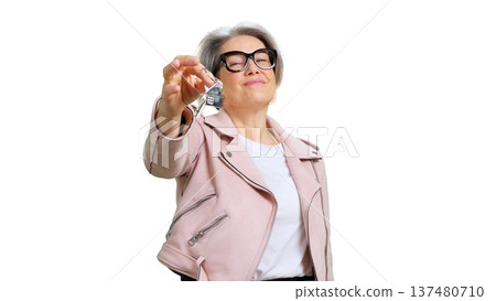 Mature woman holding up house keys buying property 137480710
