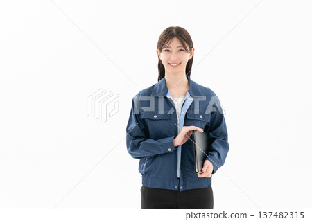 A young female engineer in work clothes on a white background A young female engineer in work clothes on a white background 137482315