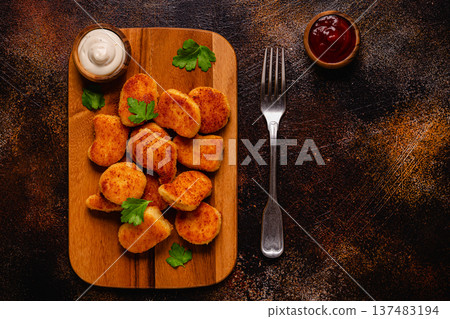 Fried crispy chicken nuggets on a wooden serving board. Fried crispy chicken nuggets on a wooden serving board. 137483194