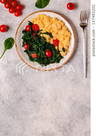 Cooked omelette and spinach with tomatoes on a light background Cooked omelette and spinach with tomatoes on a light background 137483202