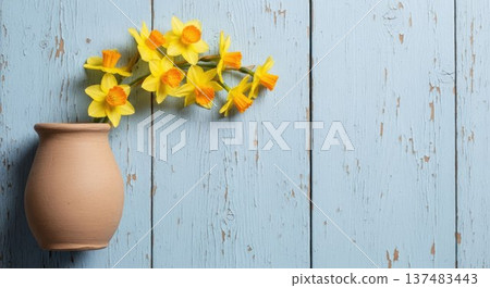Yellow daffodils in a clay vase on a rustic blue wooden background. Spring floral arrangement with copy space, symbolizing freshness, nature, and seasonal decoration Yellow daffodils in a clay vase on a rustic blue wooden background. Spring floral arrangement with copy space, symbolizing freshness, nature, and seasonal decoration 137483443