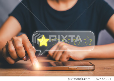 Close-up of a person giving a one-star rating on a smartphone, symbolizing feedback and review in digital platforms. 137484295