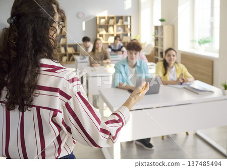 Teacher addressing students during classroom lesson and group discussion Teacher addressing students during classroom lesson and group discussion 137485494