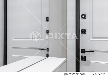 Modern White Interior Door with Sleek Black Hardware and Mirror Reflection 137485794