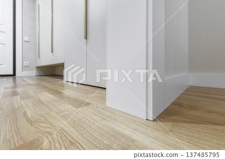 Modern Interior Detail with White Skirting Board and Oak Wood Flooring Modern Interior Detail with White Skirting Board and Oak Wood Flooring 137485795