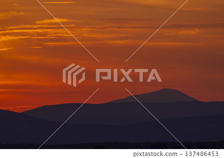 Vibrant orange sunset sky painting mountain silhouette in Provence 137486453