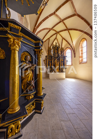 Ornate gilded pulpit and altar in historical church interior, Pribylina 137486509