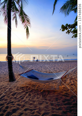 Hammock on sea beach on sunset. People on seaside. Island holiday. Hammock on sea beach on sunset. People on seaside. Island holiday. 137486856