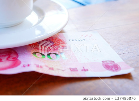 Coffee cup on table with hundred yuan bill in cafe. Payment coffee drink on breakfast. Coffee cup on table with hundred yuan bill in cafe. Payment coffee drink on breakfast. 137486876