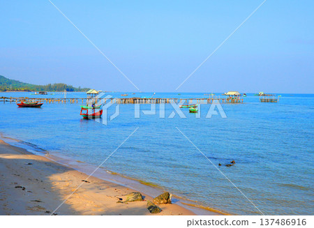 Fishing boat in calm sea near sandy beach in at fishing village. Fishing boat 137486916