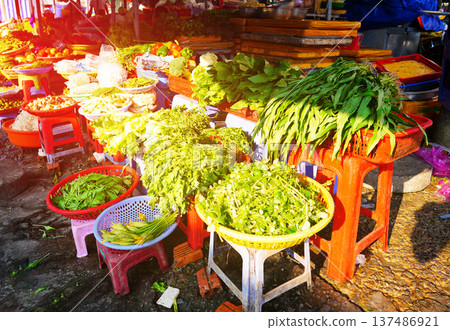 Vegetables market. Vendors display various types of fresh vegetables in baskets for sale Vegetables market. Vendors display various types of fresh vegetables in baskets for sale 137486921