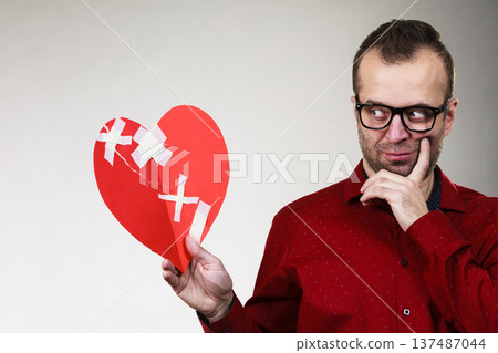 Thoughtful man holds broken heart Thoughtful man holds broken heart 137487044