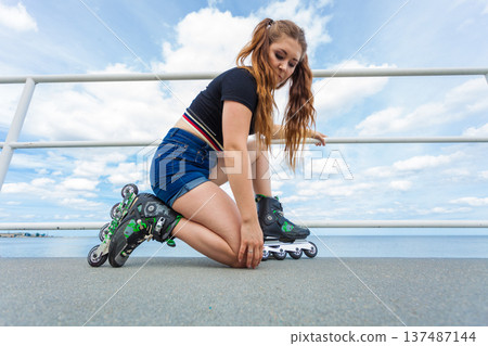 Woman putting roller skates on 137487144