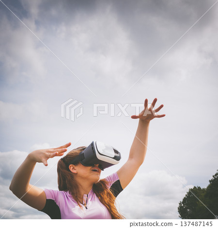 Woman wearing VR outside 137487145