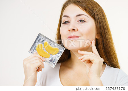Woman ready to apply gold eye patches 137487178