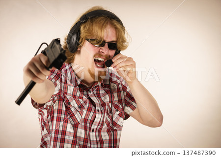 Gamer man shooting from gun Gamer man shooting from gun 137487390
