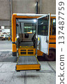 View of lowered wheelchair lift on public school bus city street 137487759